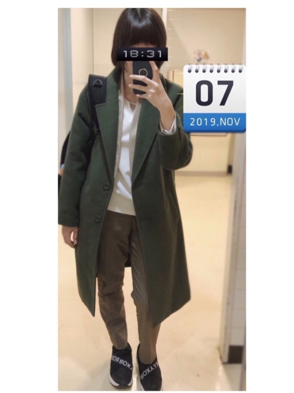 グリーン系のチェスターコート、ベージュ系のノーカラージャケット、ホワイト系のTシャツ/カットソーを着用したレディースの秋コーディネートの1枚目の写真