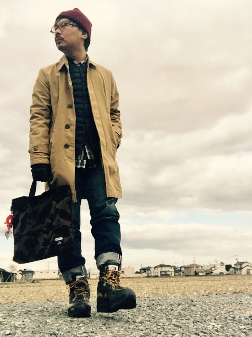 ベージュ系のステンカラーコート、ブルー系のシャツ/ブラウス、ブルー系のデニムパンツを着用したメンズの冬コーディネートの1枚目の写真