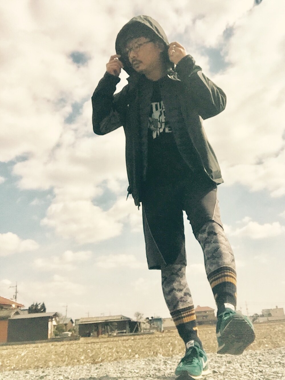 ブラック系のジャケット/アウター、ブラック系のTシャツ/カットソー、ブルー系のスニーカーを着用したメンズの冬コーディネートの1枚目の写真