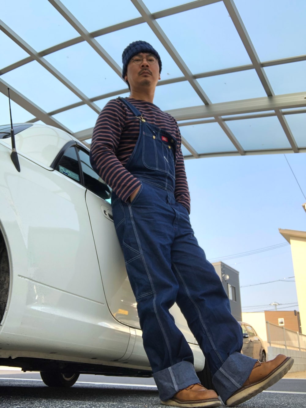 ブルー系のTシャツ/カットソー、ブルー系のサロペット/オーバーオール、ブラウン系のその他シューズを着用したメンズの春コーディネートの1枚目の写真