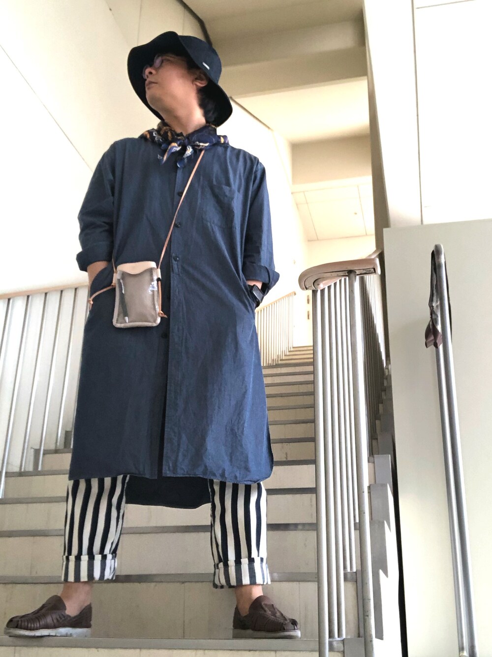 ブルー系のシャツ/ブラウス、ベージュ系のバッグ、ブルー系のデニムパンツを着用したメンズの春コーディネートの1枚目の写真