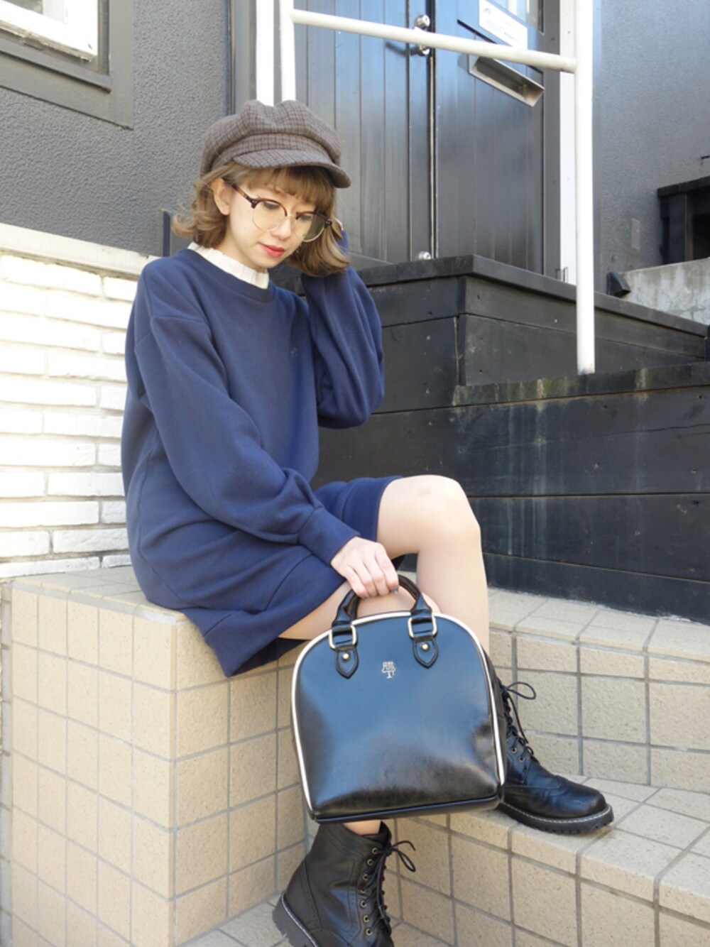 ブルー系のワンピース、ブラック系のバックパック/リュック、ブラック系のブーツを着用したレディースの冬コーディネートの1枚目の写真