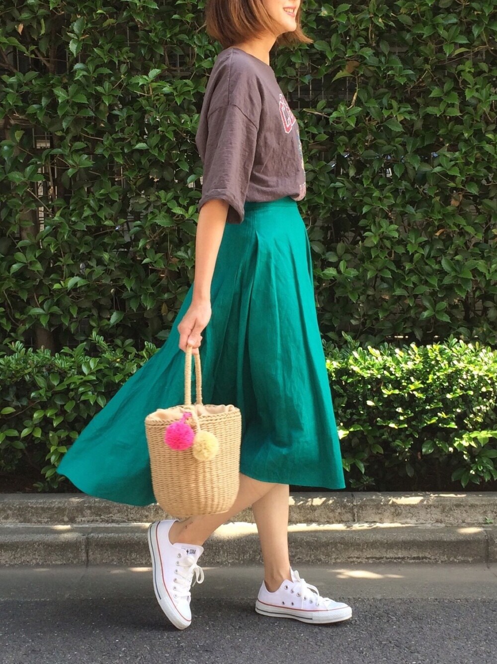 グレー系のTシャツ/カットソー、グリーン系のスカート、ベージュ系のかごバッグを着用したレディースの夏コーディネートの1枚目の写真