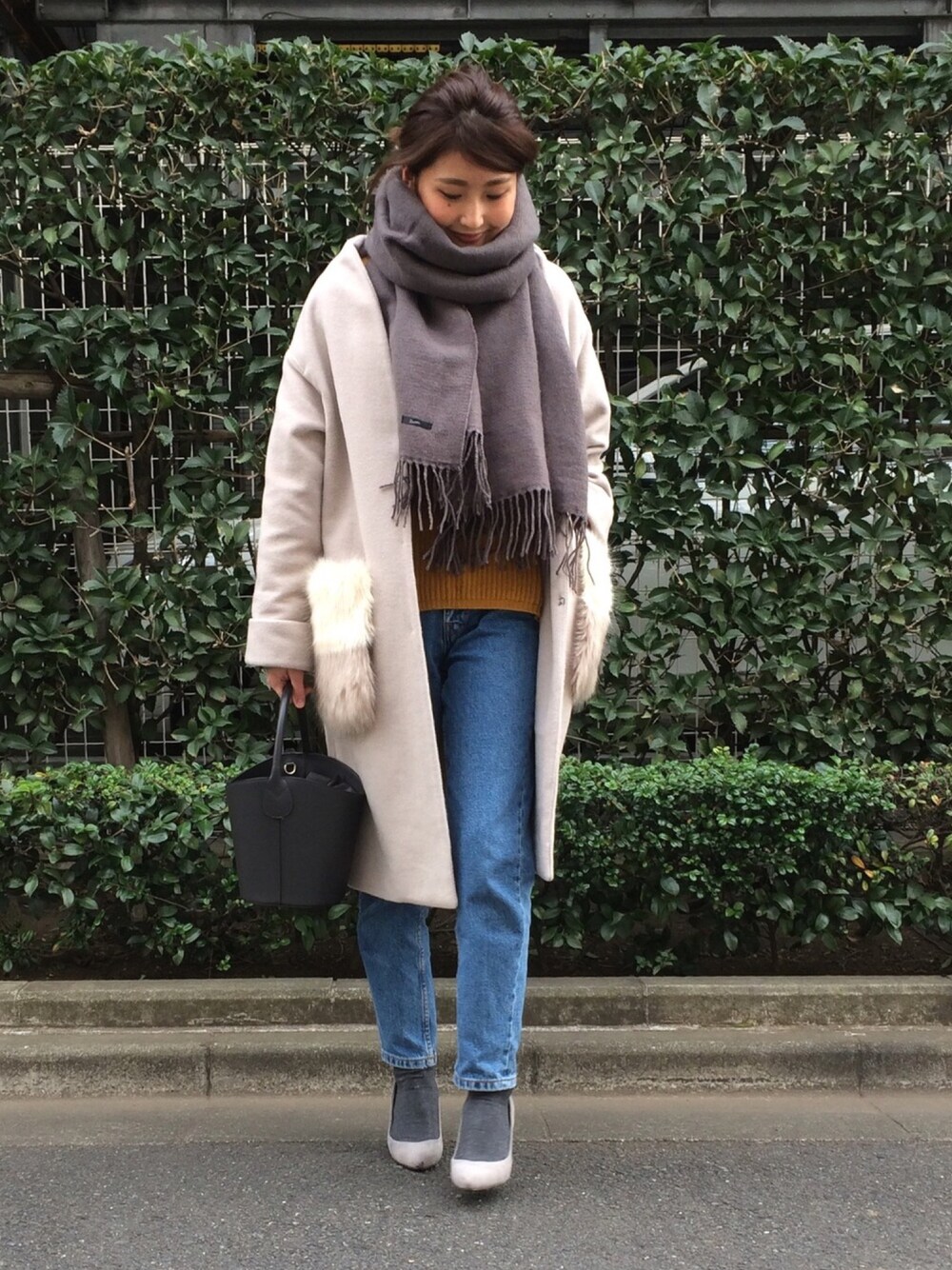 ベージュ系のノーカラージャケット、ブルー系のデニムパンツ、グレー系のショルダーバッグを着用したレディースの冬コーディネートの1枚目の写真