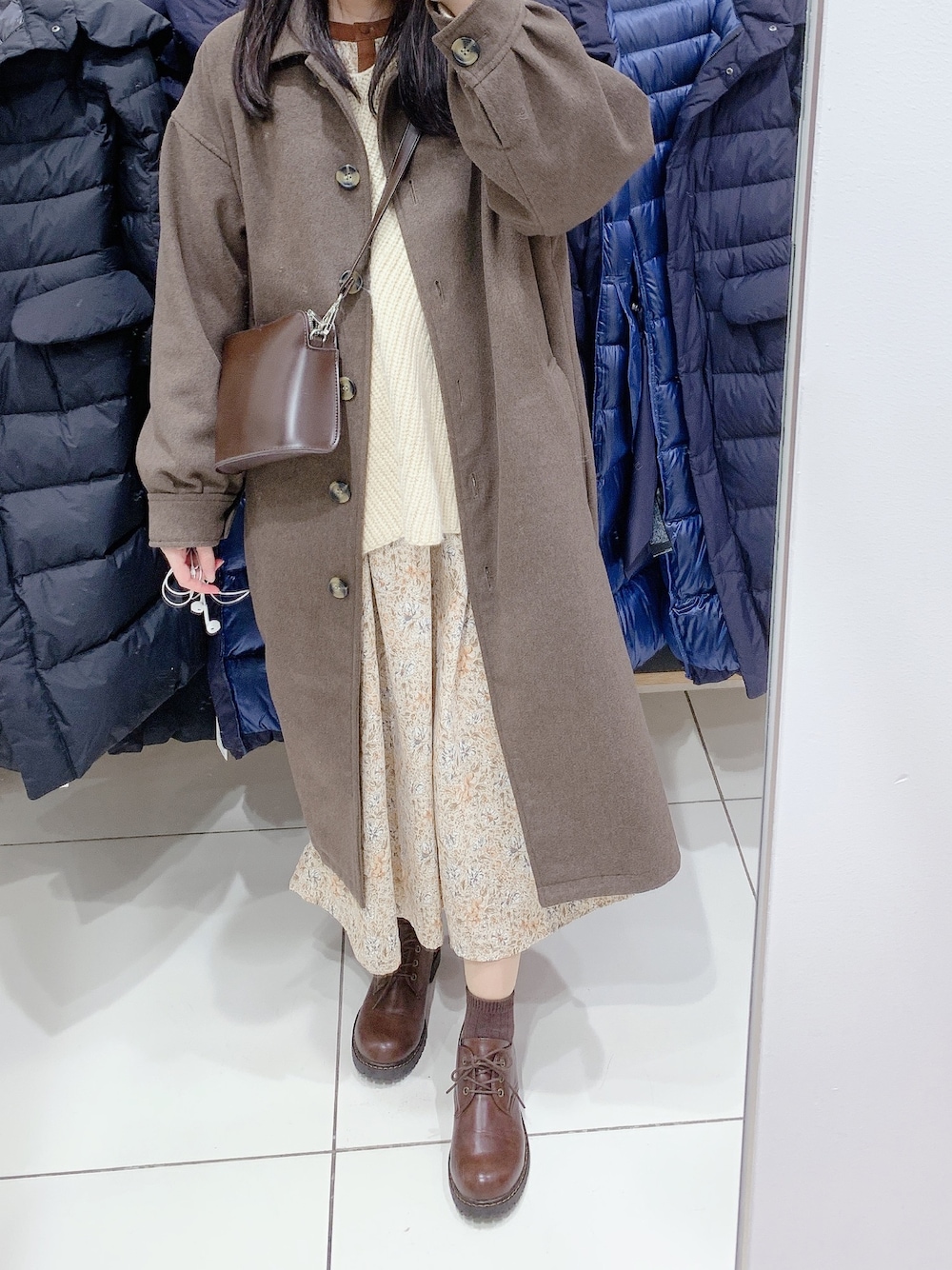 ブラウン系のステンカラーコート、ベージュ系のワンピース、ベージュ系のニット/セーターを着用したレディースの冬コーディネートの1枚目の写真