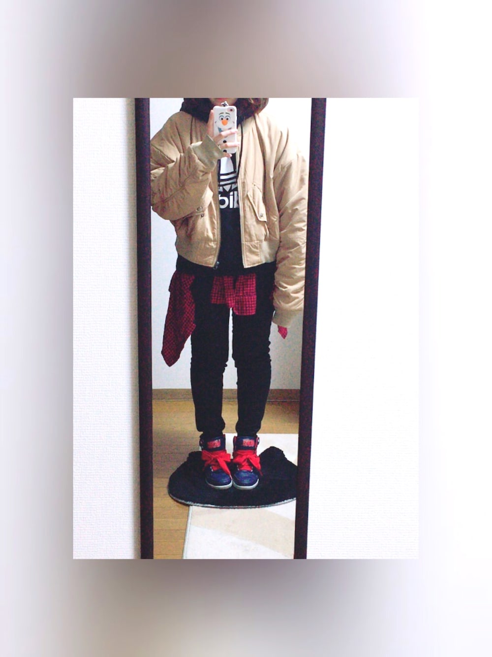 ベージュ系のMA-1、ブラック系のパーカーを着用したレディースの冬コーディネートの1枚目の写真