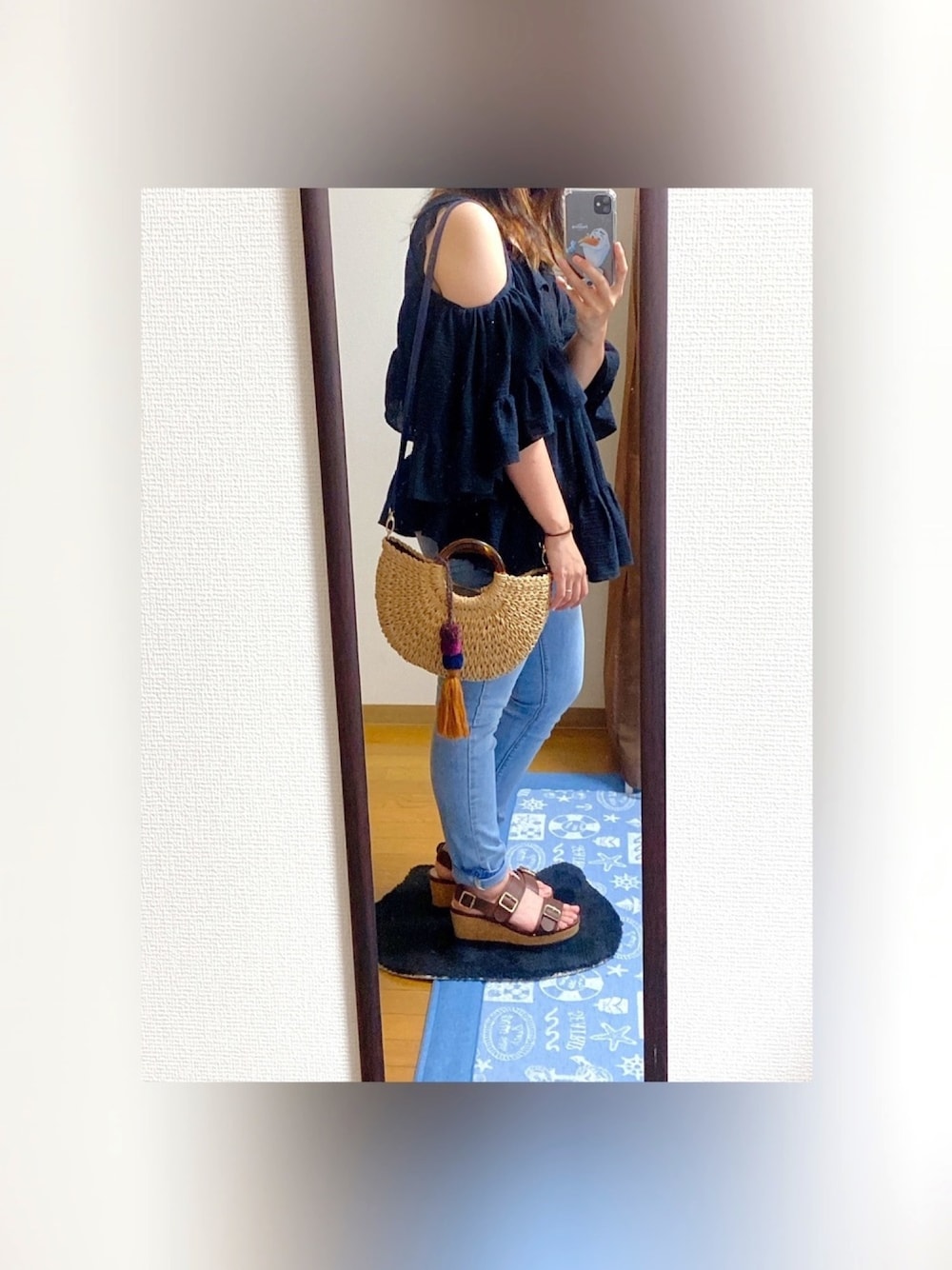 ブラック系のチュニック、ブラック系のタンクトップ、ブルー系のデニムパンツを着用したレディースの夏コーディネートの1枚目の写真