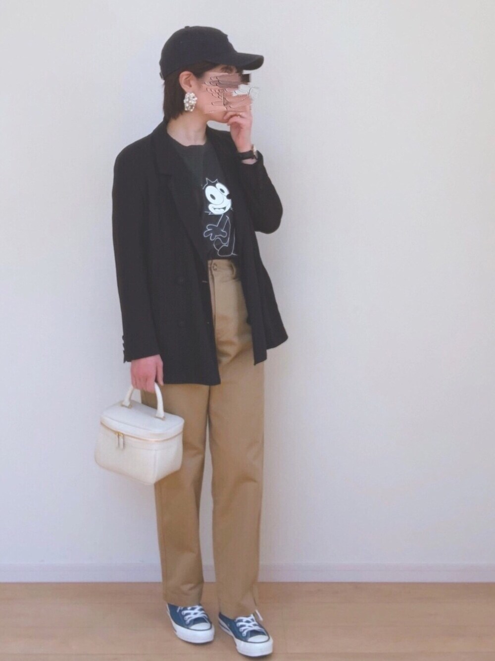 ベージュ系のチノパンツ、ブルー系のスニーカー、ブルー系のキャップを着用したレディースの春コーディネートの1枚目の写真