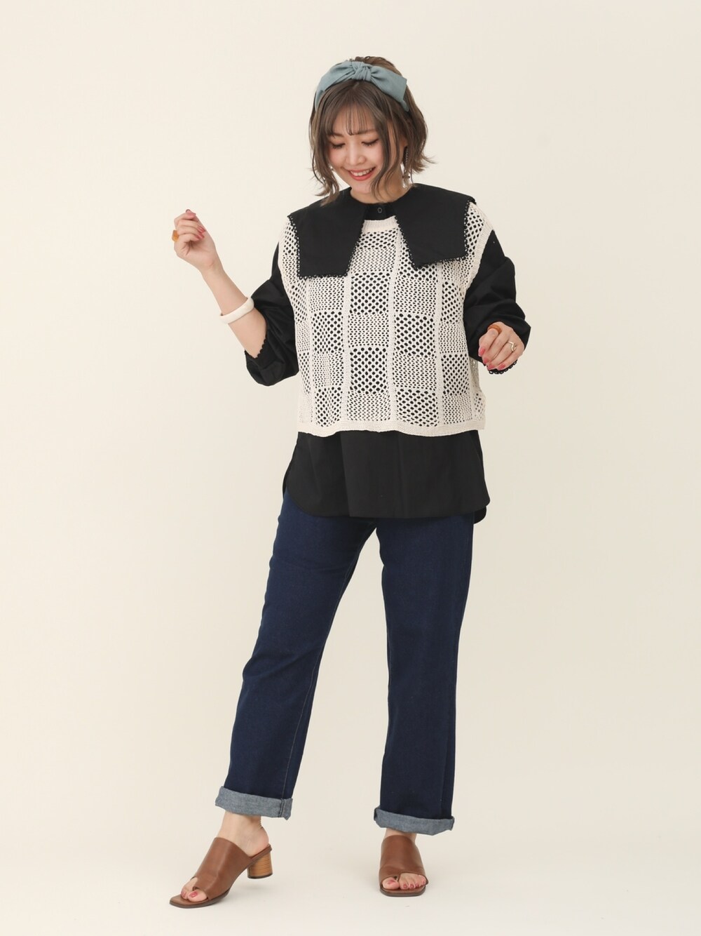 ブラック系のシャツ/ブラウス、ブルー系のデニムパンツ、ホワイト系のベストを着用したレディースの春コーディネートの1枚目の写真