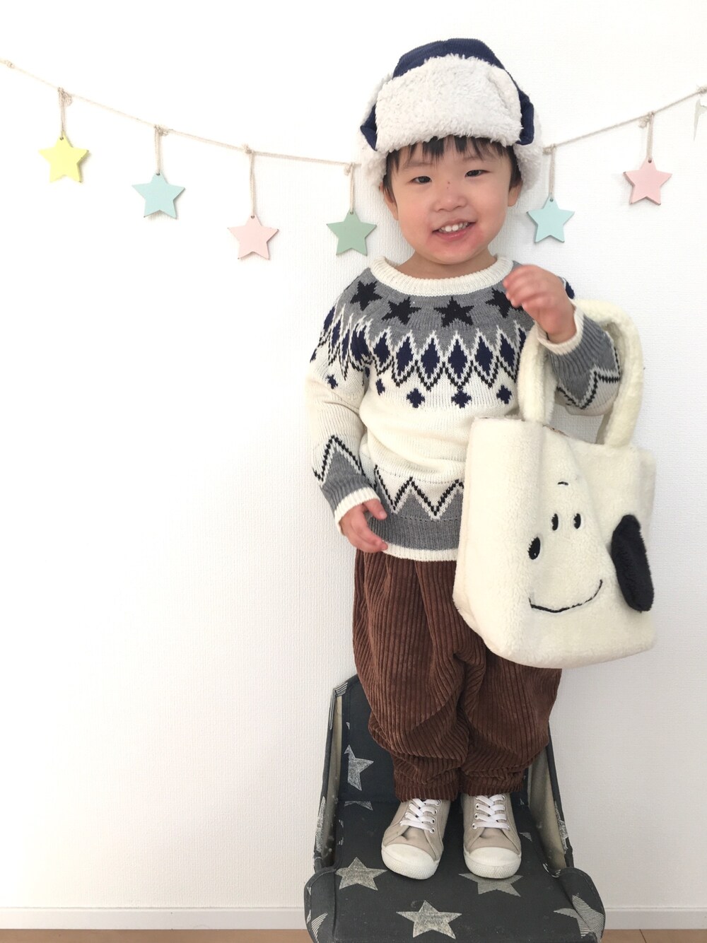 ホワイト系のトートバッグ、ホワイト系のニット/セーター、ブラウン系のその他パンツを着用したキッズの冬コーディネートの1枚目の写真