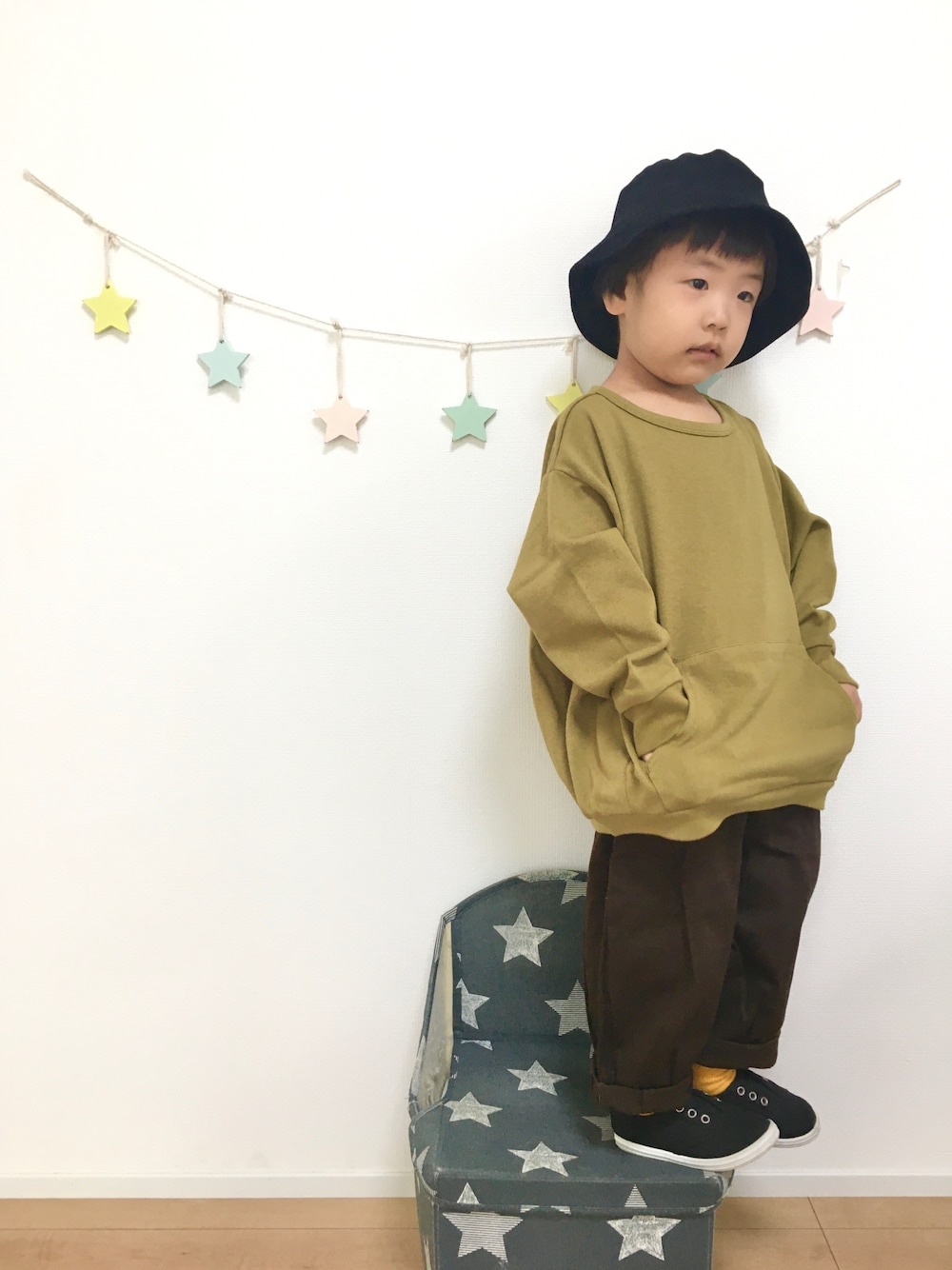 イエロー系のTシャツ/カットソー、ブラウン系のその他パンツ、ブラック系のスニーカーを着用したキッズの秋コーディネートの1枚目の写真