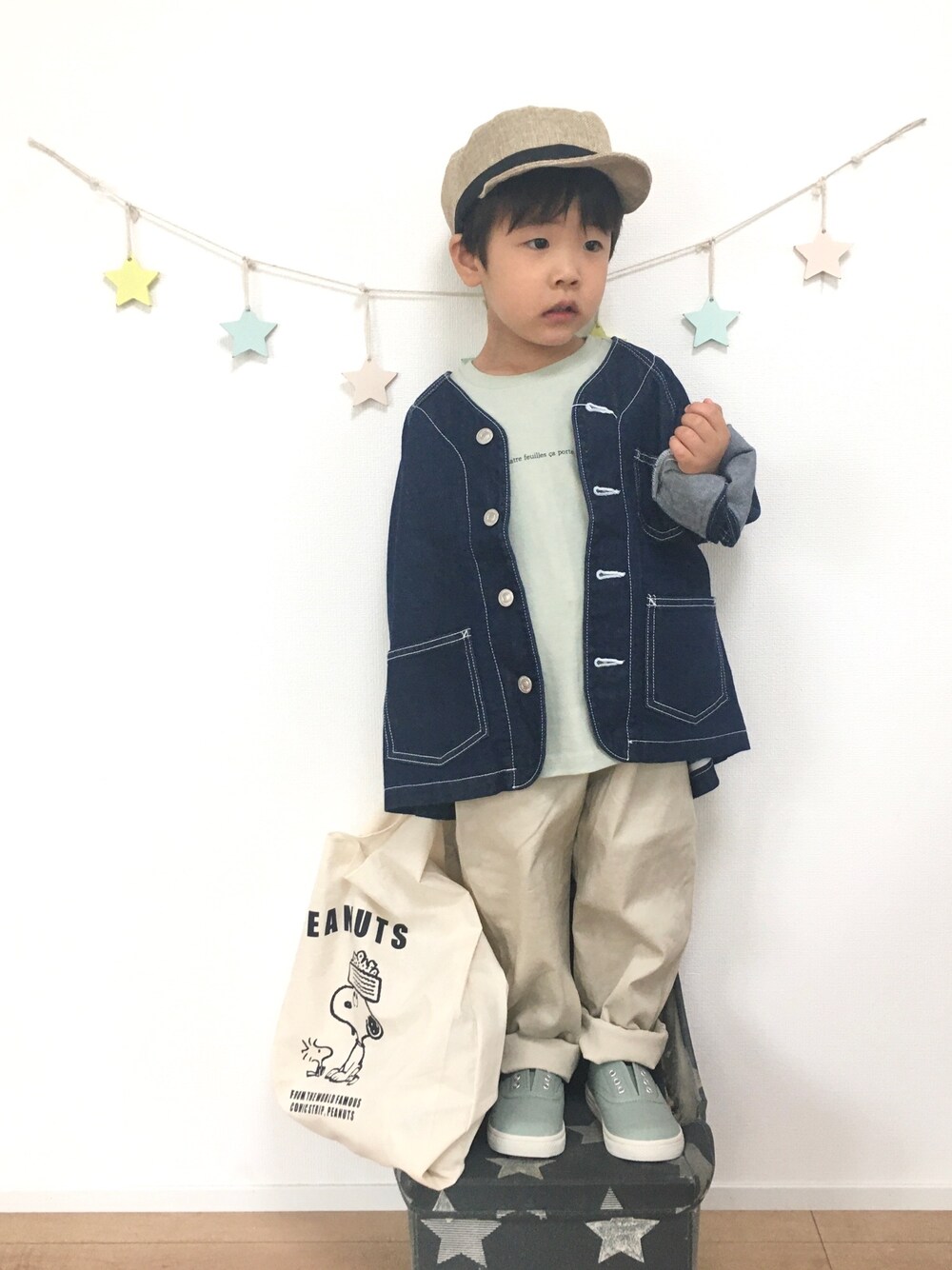 ブルー系のデニムジャケット、グリーン系のTシャツ/カットソー、ホワイト系のエコバッグ/サブバッグを着用したキッズの春コーディネートの1枚目の写真
