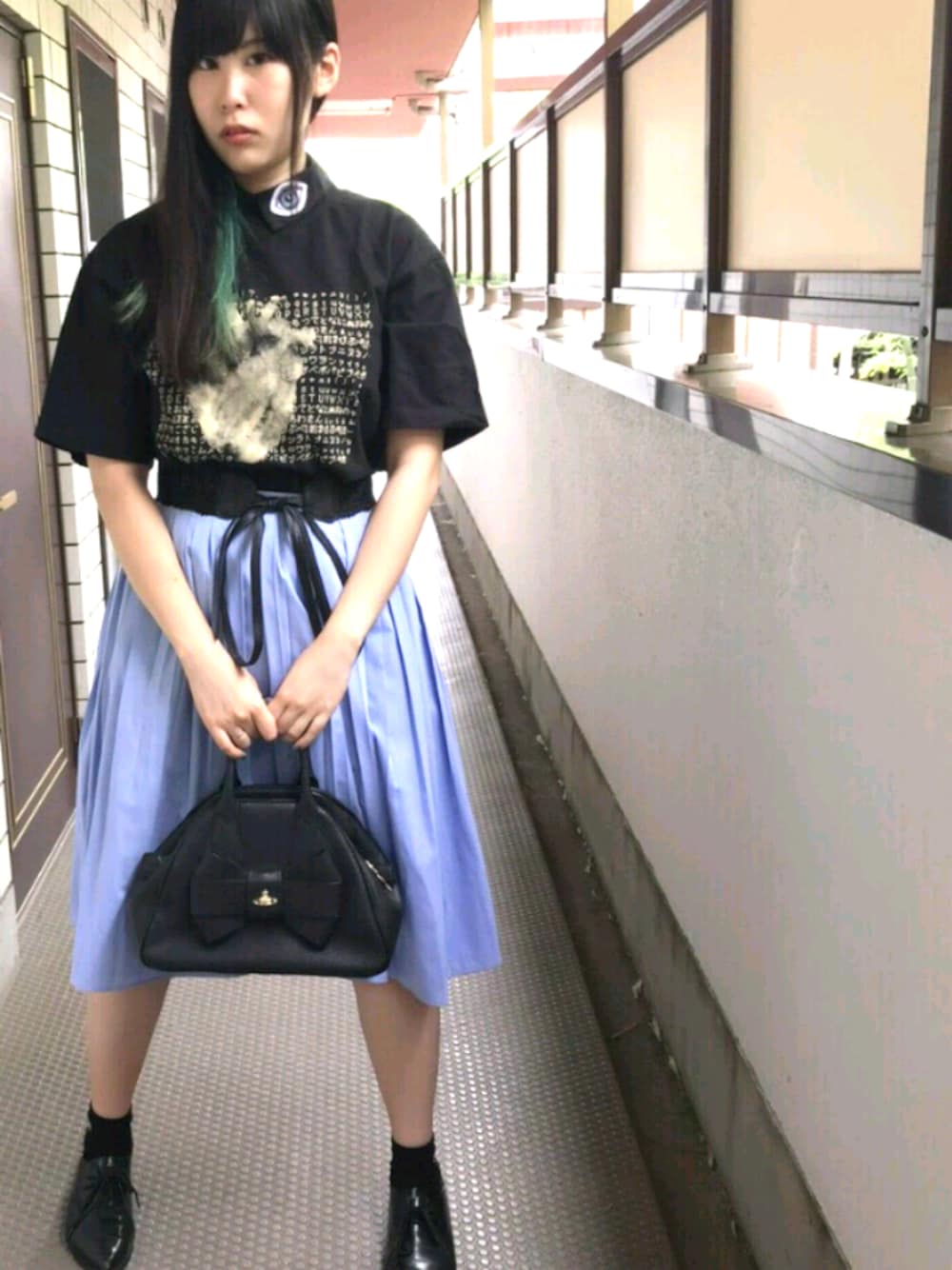 ブラック系のTシャツ/カットソー、ブラック系のハンドバッグ、ブラック系のパンプスを着用したレディースの夏コーディネートの1枚目の写真