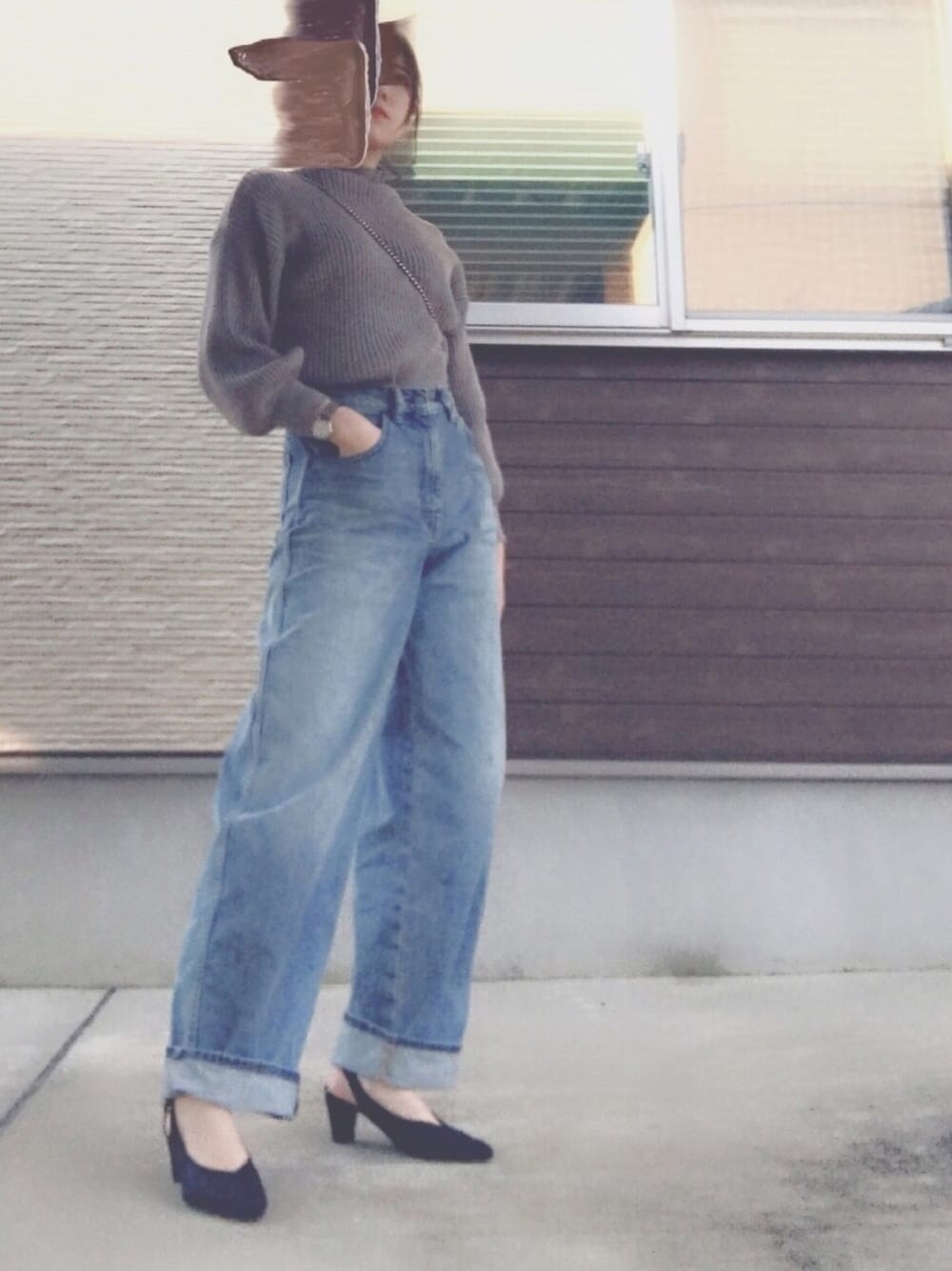 ブルー系のデニムパンツ、ブラック系のサンダル、グレー系のニット/セーターを着用したレディースの春コーディネートの1枚目の写真