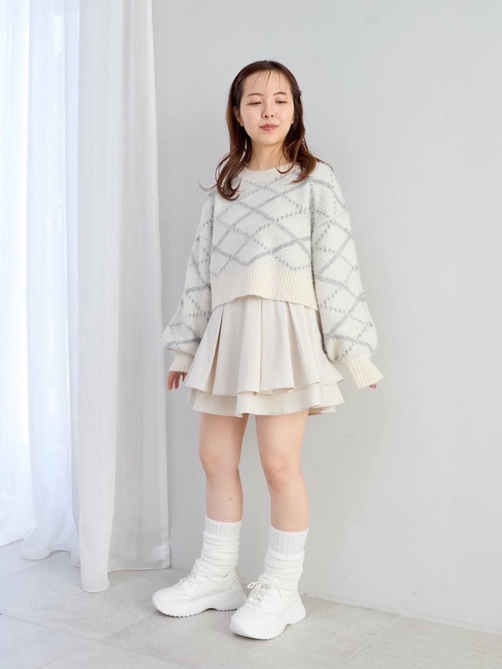 ホワイト系のスカート、ホワイト系のスニーカー、ホワイト系のニット/セーターを着用したレディースの冬コーディネートの1枚目の写真