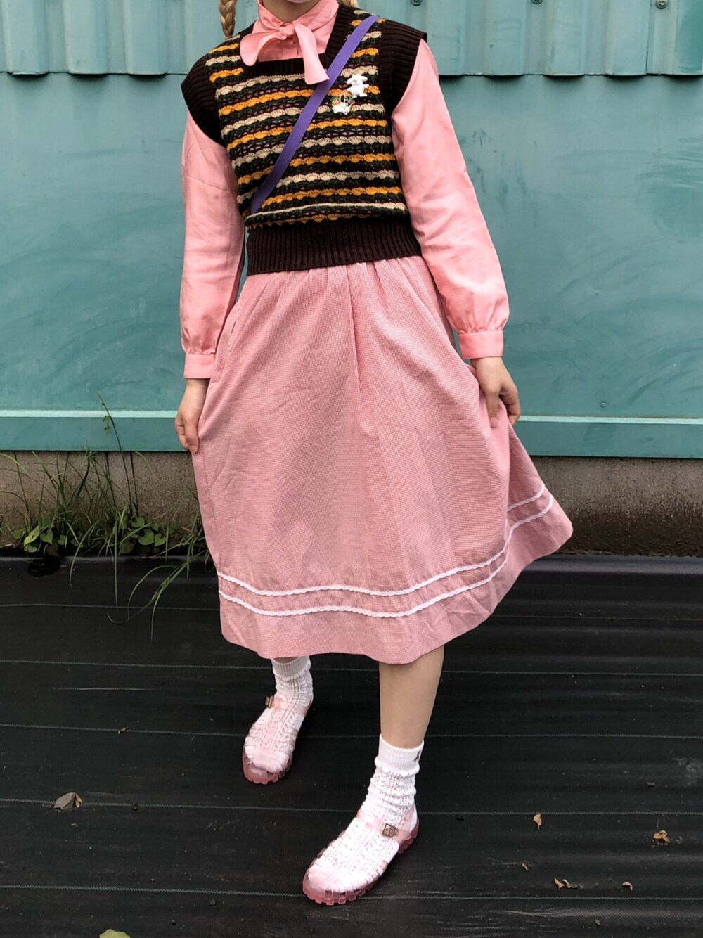 レッド系のスカート、ピンク系のシャツ/ブラウス、ブラウン系のベストを着用したレディースの春コーディネートの1枚目の写真