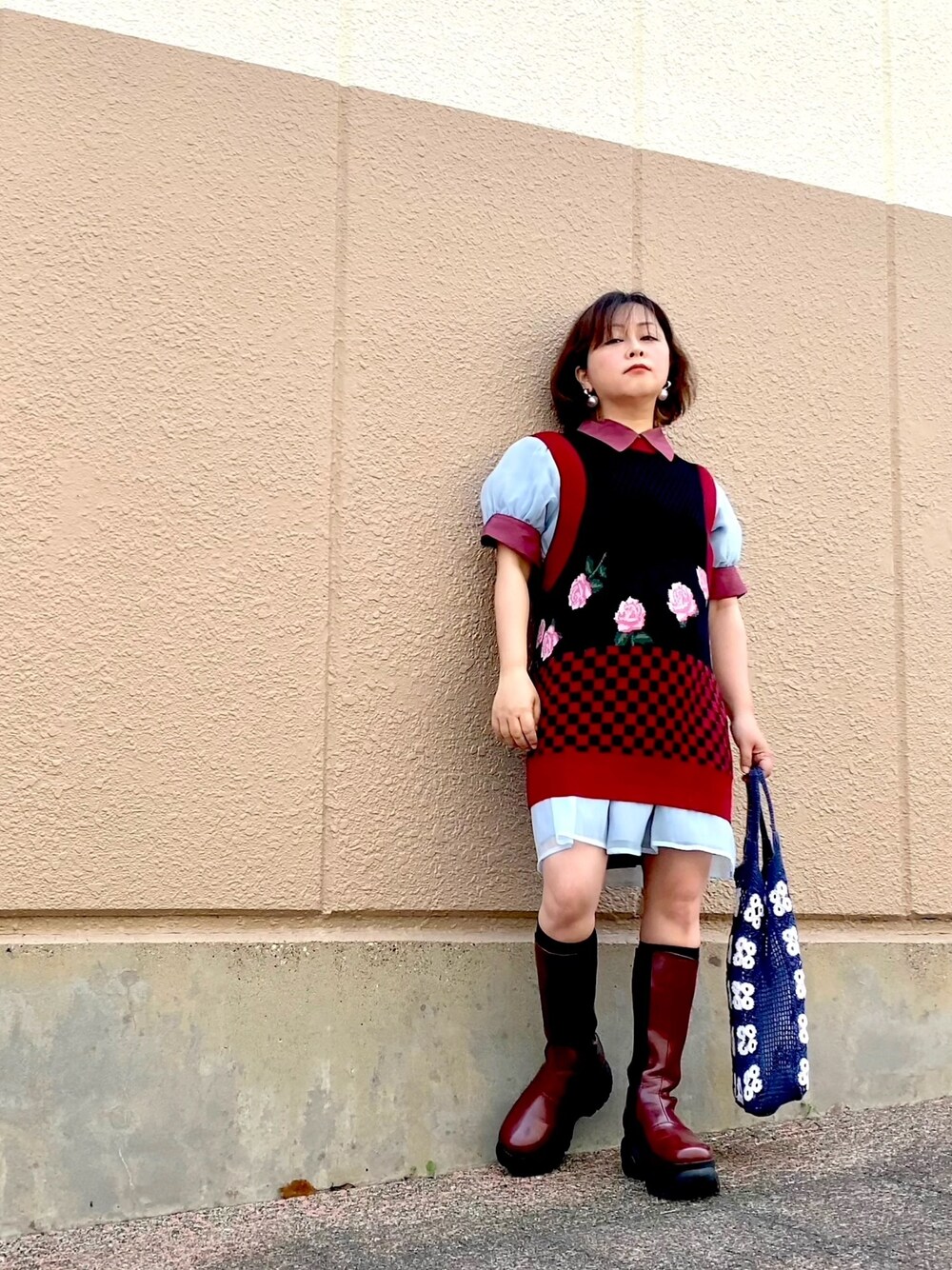 ブルー系のワンピース、ブラック系のベスト、レッド系のブーツを着用したレディースの夏コーディネートの1枚目の写真