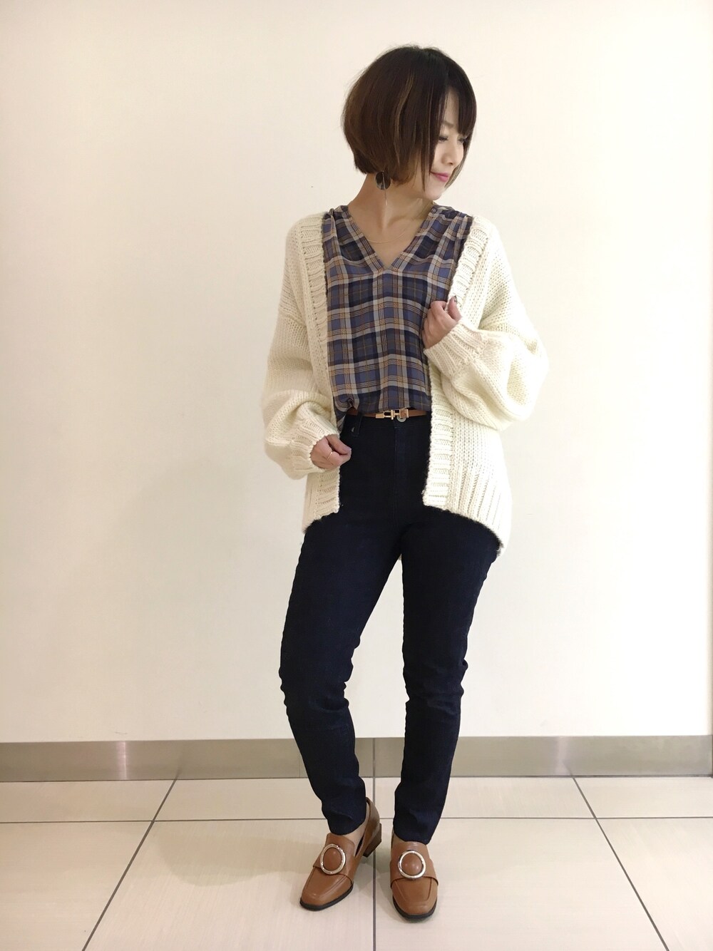 ベージュ系のカーディガン/ボレロ、ブルー系のシャツ/ブラウス、ブルー系のデニムパンツを着用したレディースの秋コーディネートの1枚目の写真