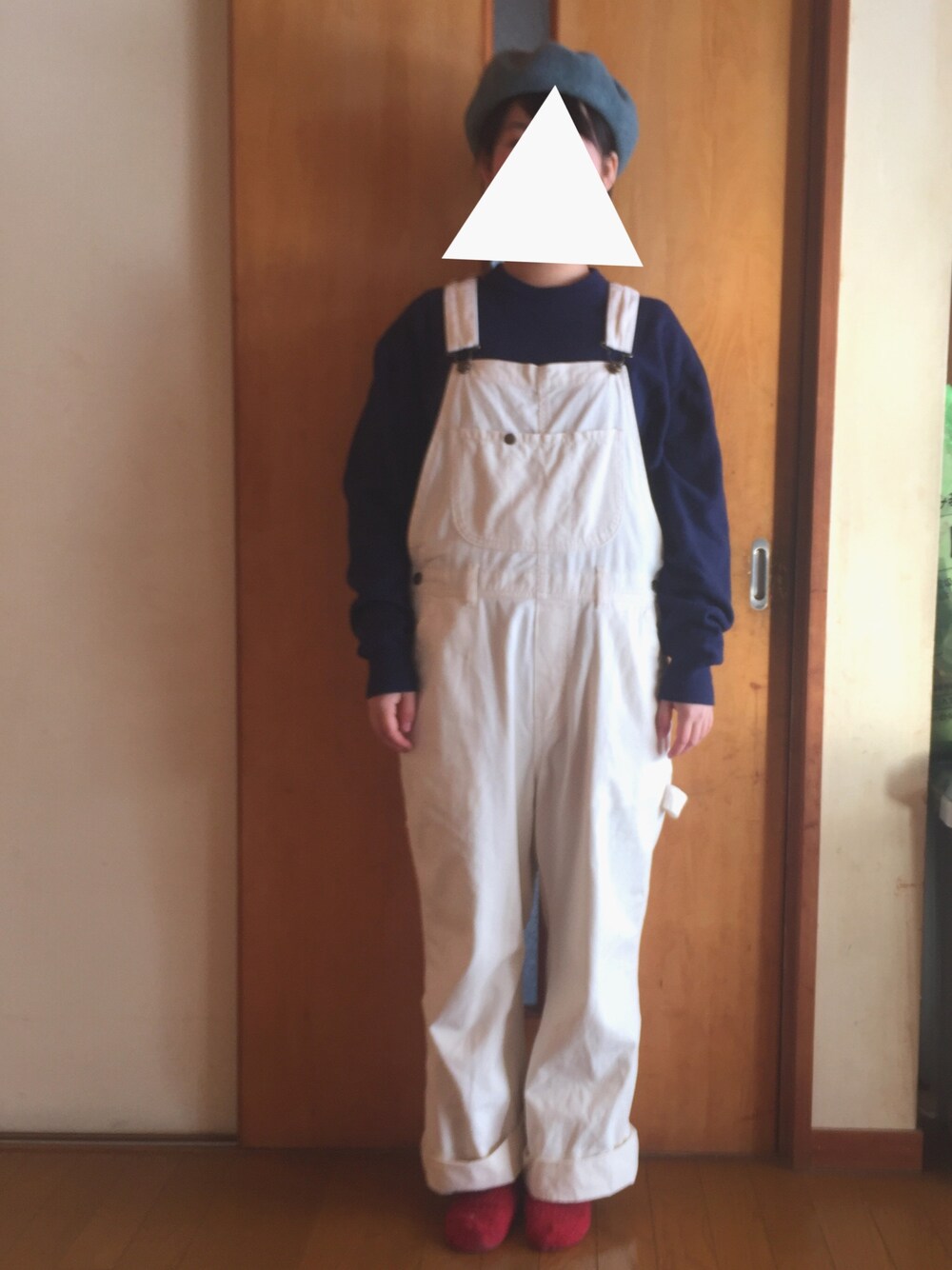 ブルー系のニット/セーター、ホワイト系のサロペット/オーバーオール、ブルー系のハンチング/ベレー帽を着用したレディースの冬コーディネートの1枚目の写真