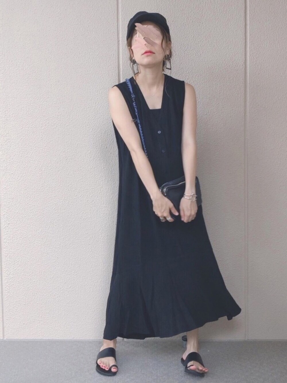 ブラック系のワンピース、ブラック系のサンダル、ブラック系のキャップを着用したレディースの夏コーディネートの1枚目の写真