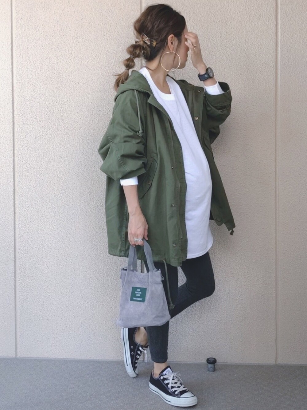 グリーン系のモッズコート、ホワイト系のTシャツ/カットソー、グレー系のショルダーバッグを着用したレディースの秋コーディネートの1枚目の写真