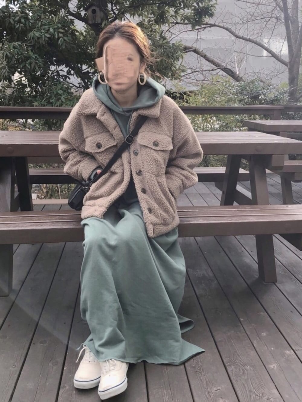 グリーン系のワンピース、ベージュ系のジャケット/アウター、ホワイト系のスニーカーを着用したレディースの冬コーディネートの1枚目の写真