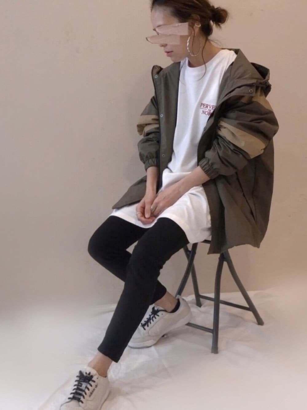 グリーン系のマウンテンパーカー、ホワイト系のTシャツ/カットソー、ブラック系のその他パンツを着用したレディースの春コーディネートの1枚目の写真