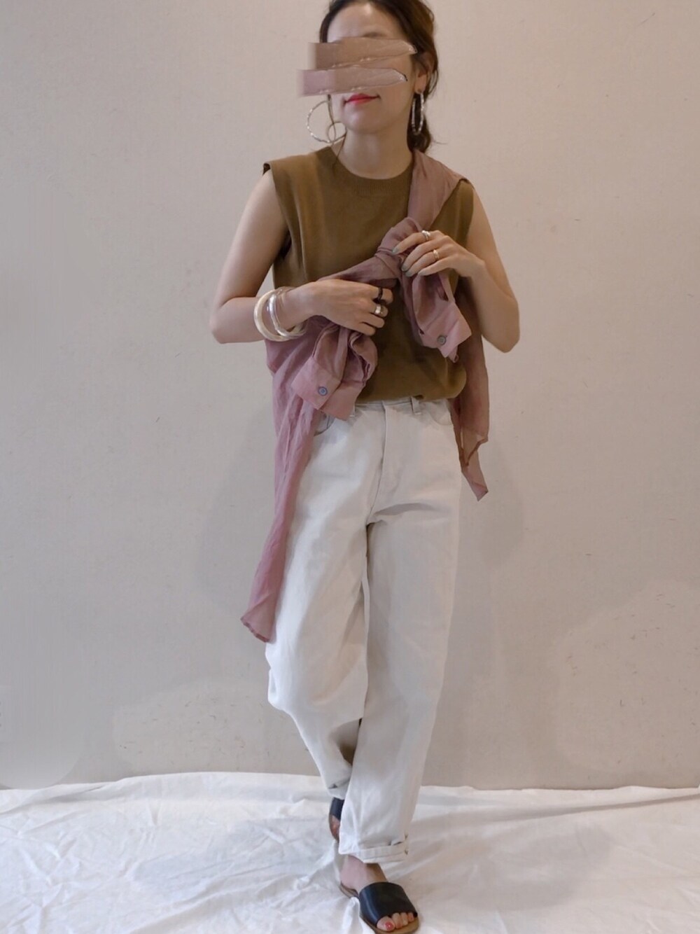 ブラウン系のシャツ/ブラウス、イエロー系のタンクトップ、ホワイト系のその他パンツを着用したレディースの春コーディネートの1枚目の写真