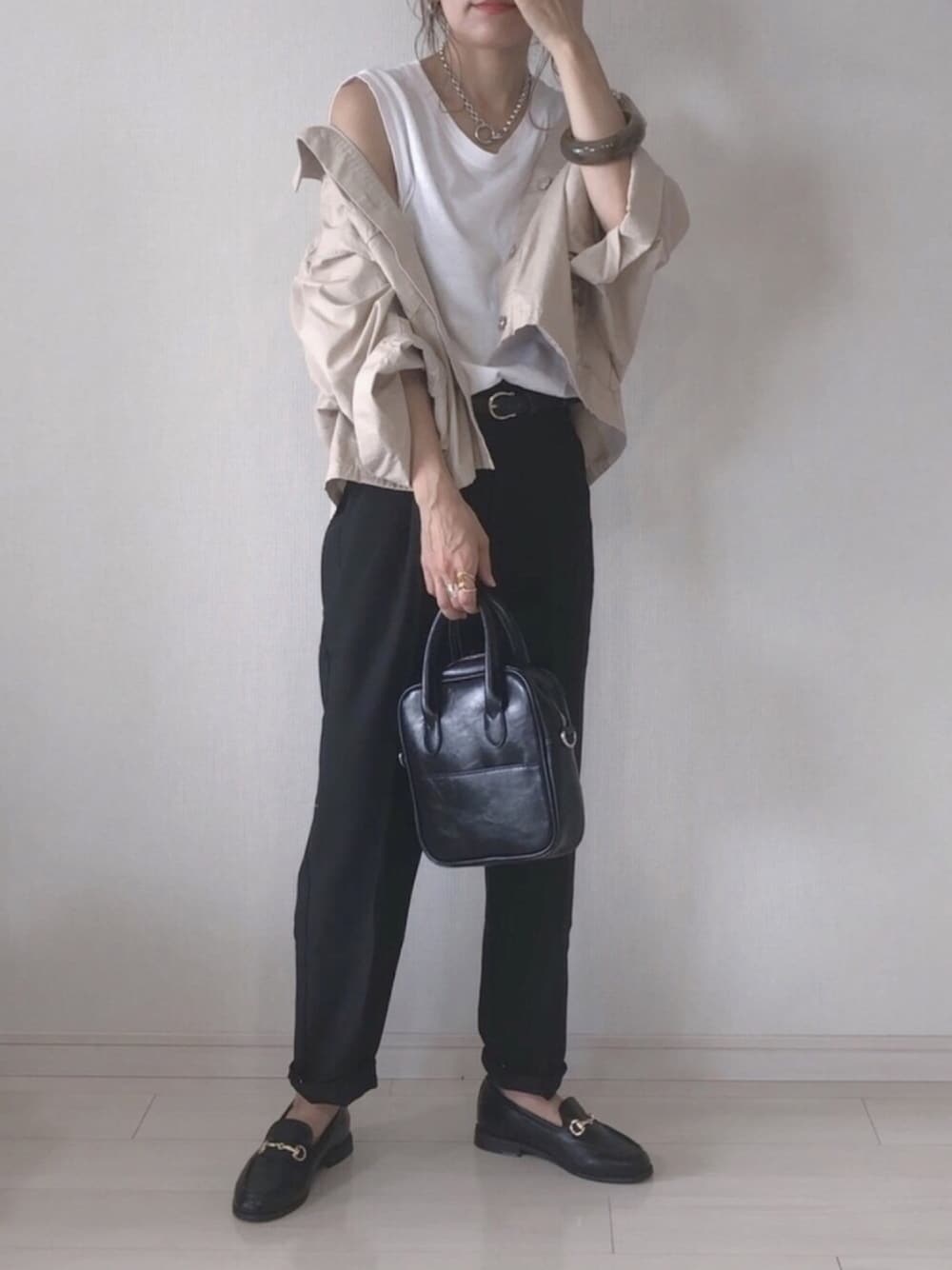 ブラック系のその他パンツ、ホワイト系のタンクトップ、ベージュ系のその他アウターを着用したレディースの秋コーディネートの1枚目の写真