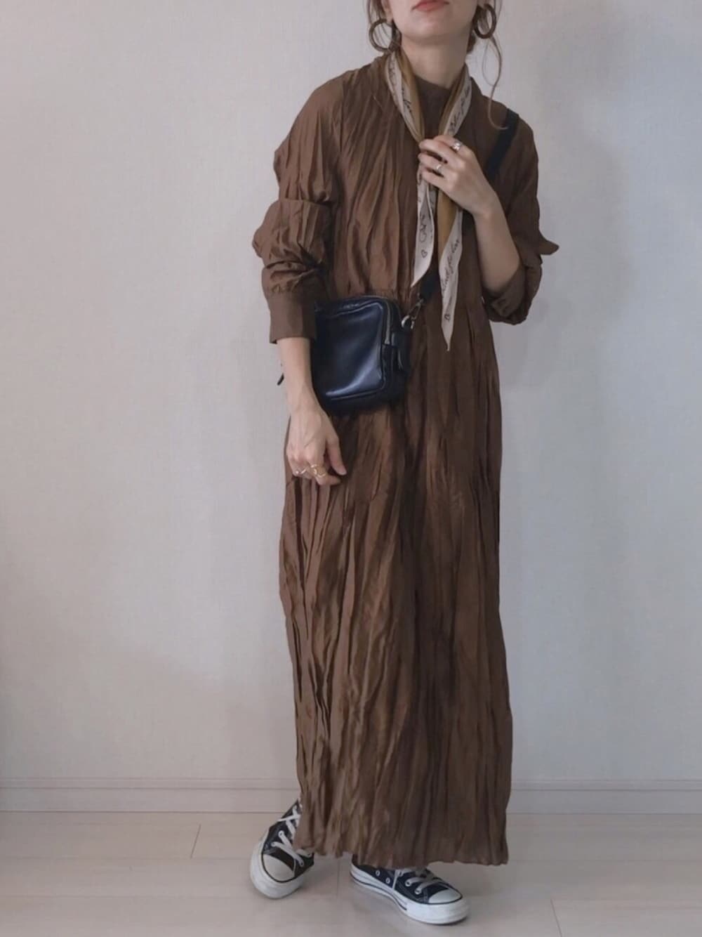 ブラウン系のワンピース、ブラック系のスニーカー、イエロー系のバンダナ/スカーフを着用したレディースの秋コーディネートの1枚目の写真