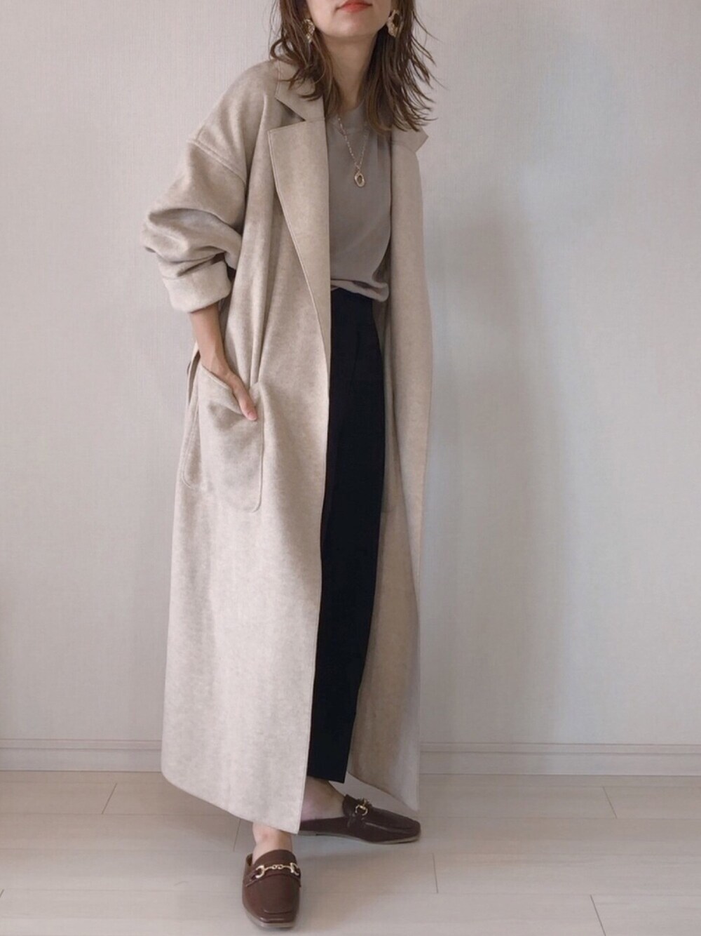 ベージュ系のチェスターコート、その他のニット/セーター、ブラック系のその他パンツを着用したレディースの秋コーディネートの1枚目の写真