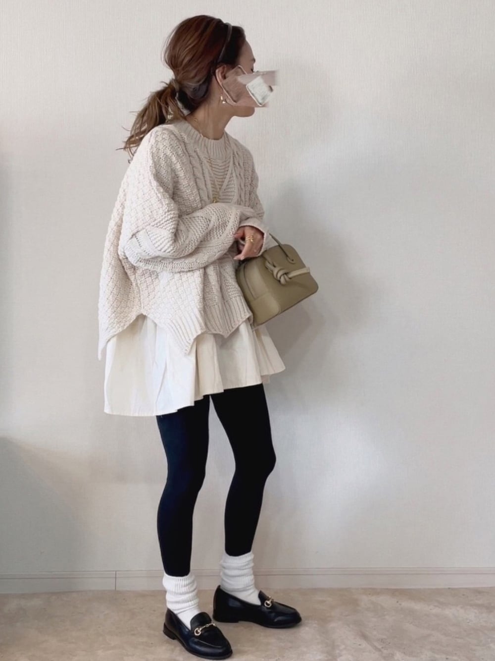 ホワイト系のニット/セーター、ブラック系のその他シューズ、ベージュ系のバッグを着用したレディースの冬コーディネートの1枚目の写真