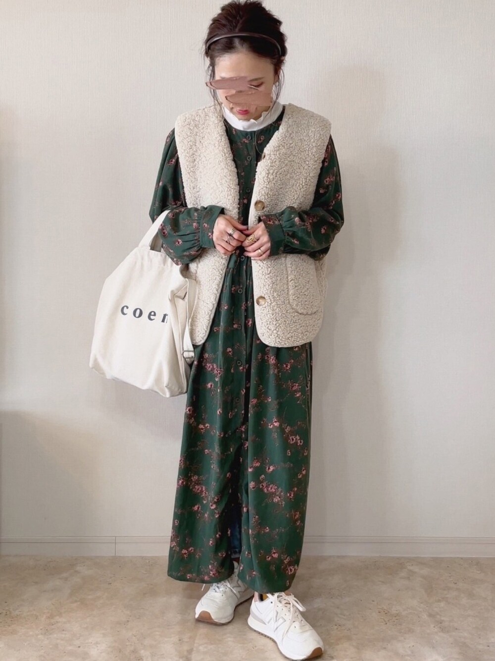 グリーン系のワンピース、ベージュ系のベスト、ホワイト系のTシャツ/カットソーを着用したレディースの冬コーディネートの1枚目の写真