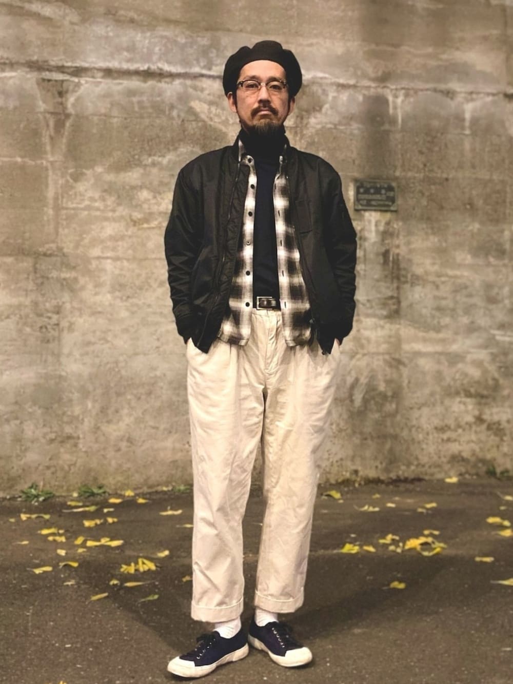 ホワイト系のチノパンツ、ブルー系のスニーカー、ブラック系のMA-1を着用したメンズの冬コーディネートの1枚目の写真