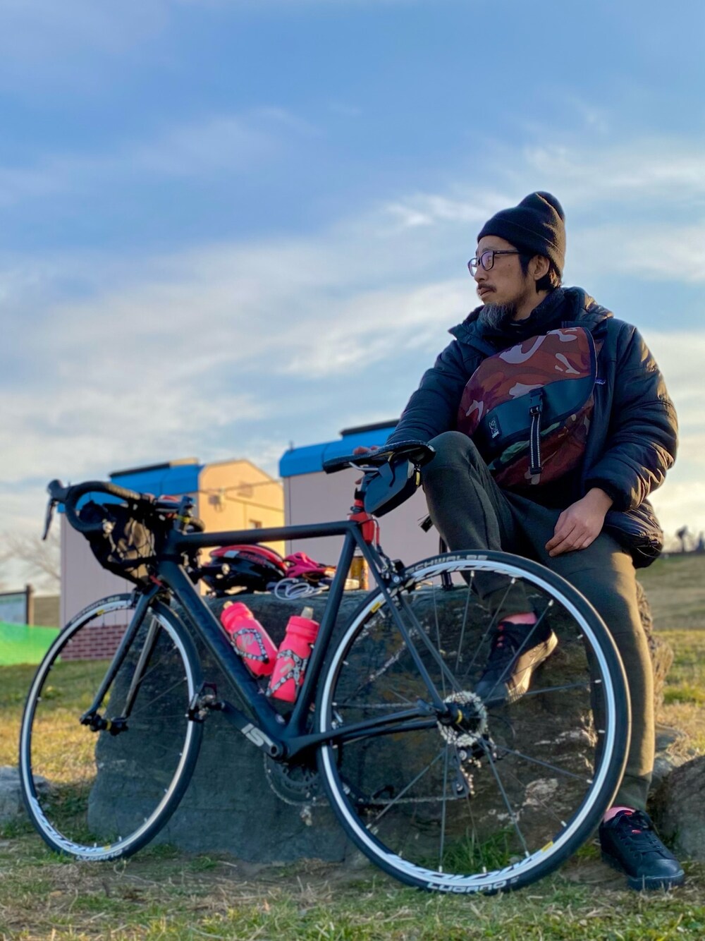 ブラウン系のメッセンジャーバッグ、ブラック系のナイロンジャケット、グレー系のその他パンツを着用したメンズの冬コーディネートの1枚目の写真