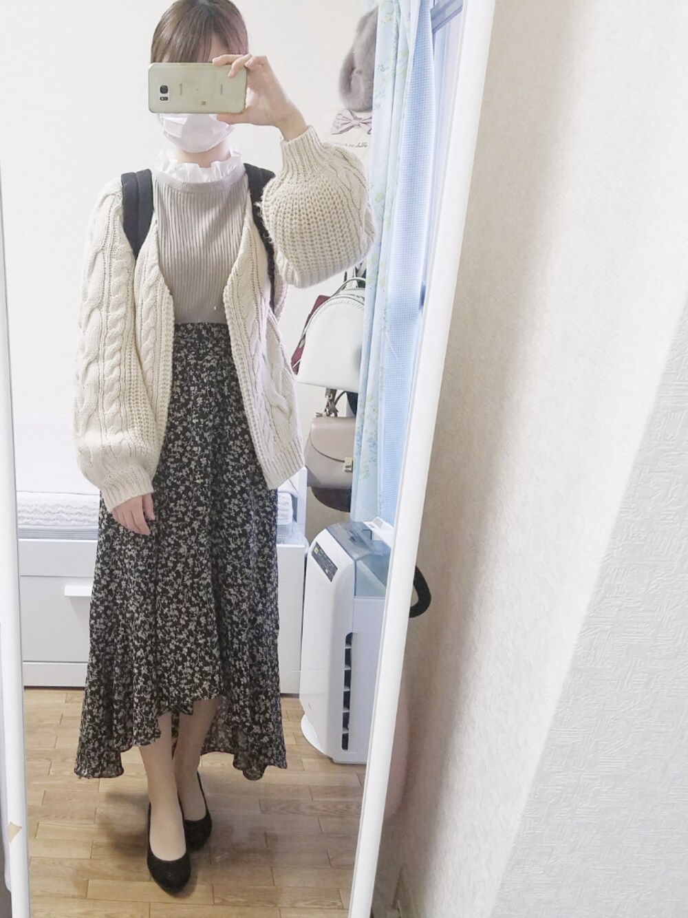 ベージュ系のカーディガン/ボレロ、ベージュ系のニット/セーター、ブラック系のスカートを着用したレディースの秋コーディネートの1枚目の写真