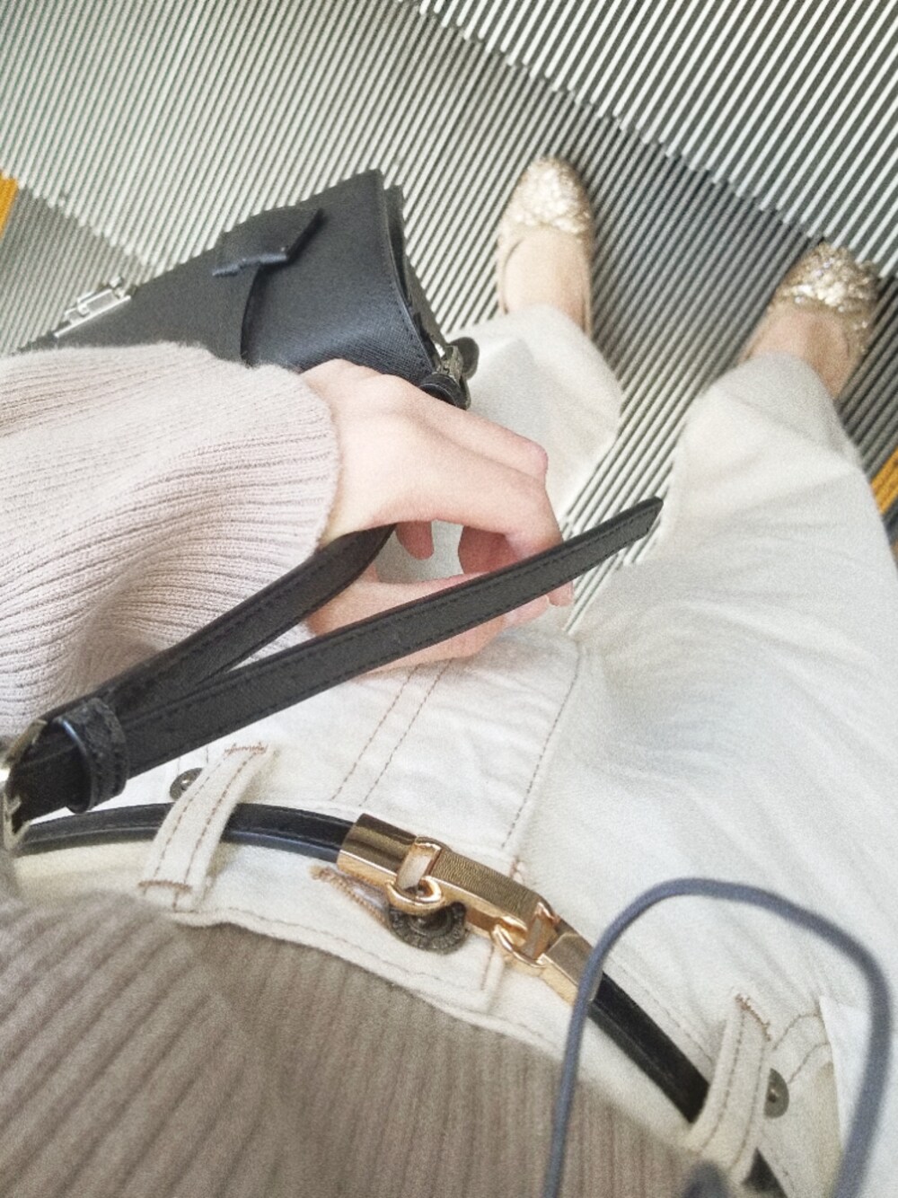 ホワイト系のデニムパンツ、ゴールド系のバレエシューズ、ブラック系のハンドバッグを着用したレディースの秋コーディネートの1枚目の写真