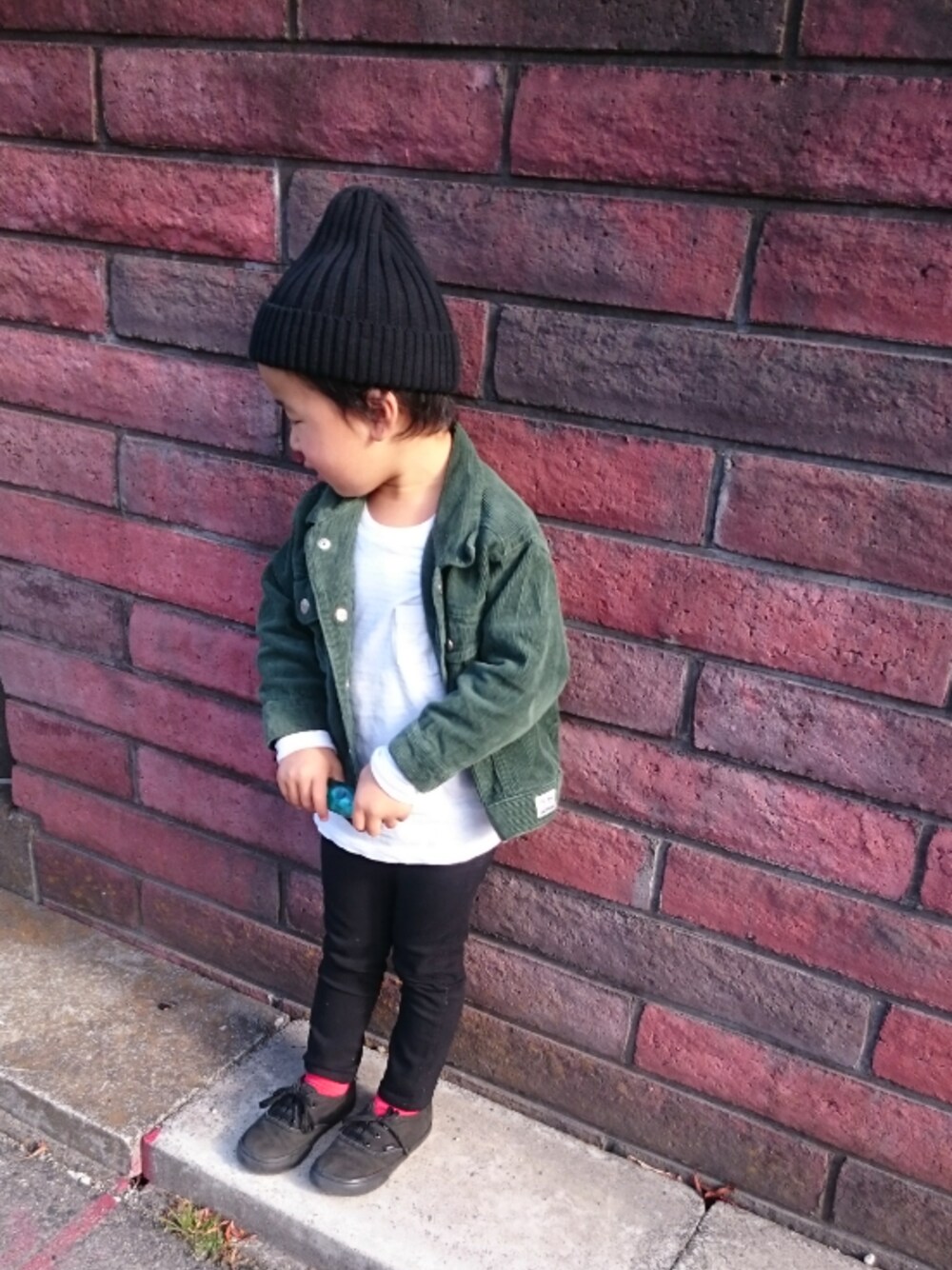 グリーン系のジャケット/アウター、ブラック系のスニーカー、ホワイト系のTシャツ/カットソーを着用したキッズの冬コーディネートの1枚目の写真