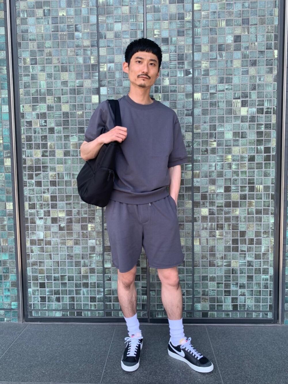 ブラック系のスニーカー、ブラック系のトートバッグ、グレー系のTシャツ/カットソーを着用したメンズの夏コーディネートの1枚目の写真