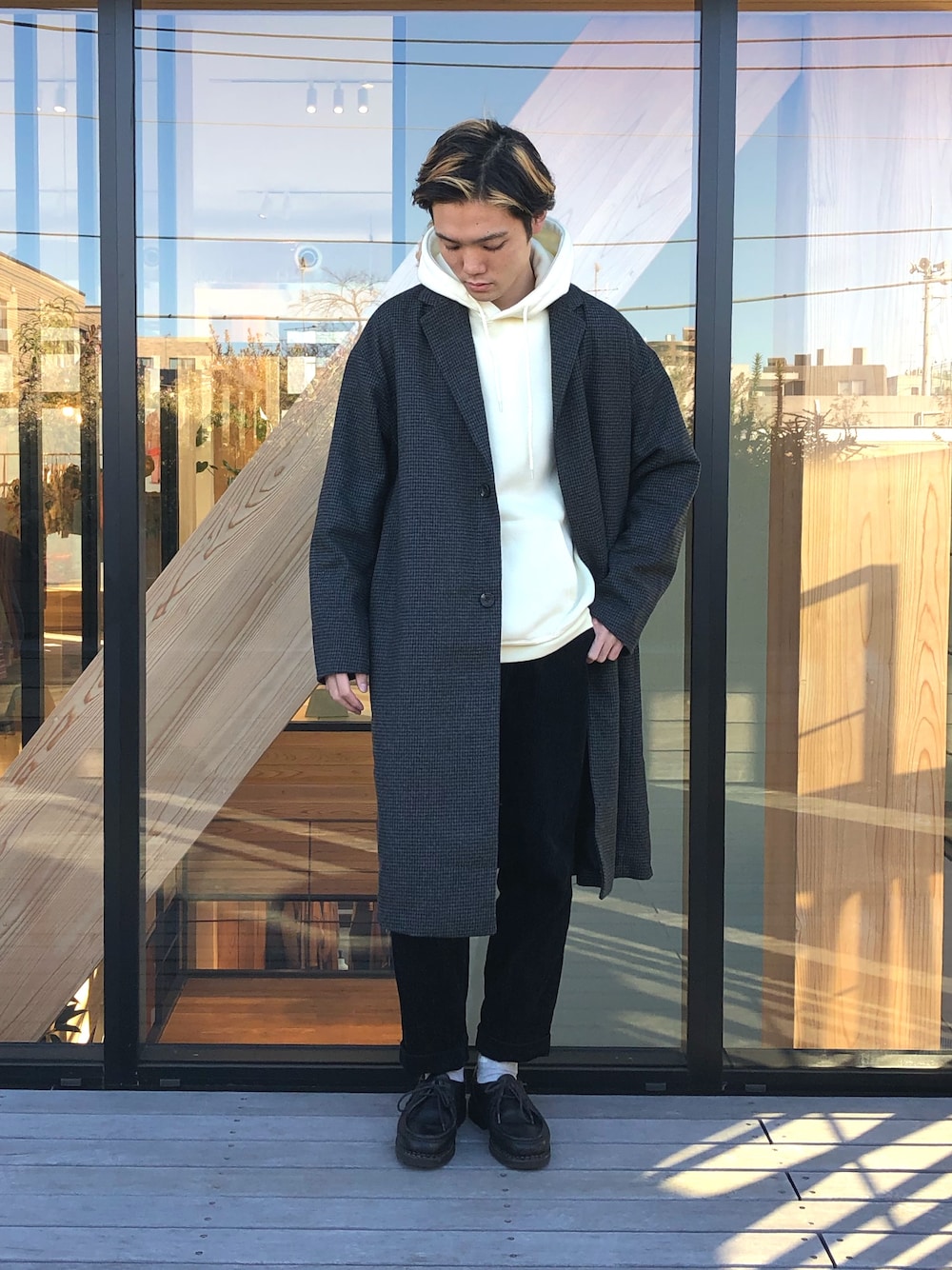 グレー系のダウンジャケット/コート、ホワイト系のパーカー、ブラック系のブーツを着用したメンズの冬コーディネートの1枚目の写真