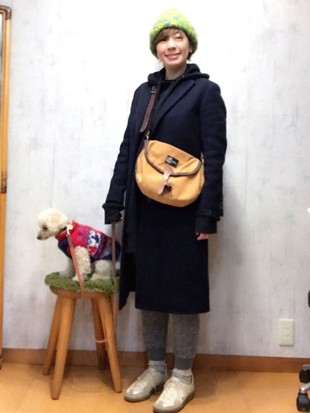 ブルー系のチェスターコート、グレー系のその他パンツ、ホワイト系のスニーカーを着用したレディースの冬コーディネートの1枚目の写真