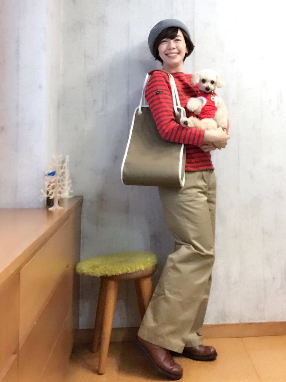 グリーン系のトートバッグ、ベージュ系のチノパンツ、レッド系のTシャツ/カットソーを着用したレディースの秋コーディネートの1枚目の写真