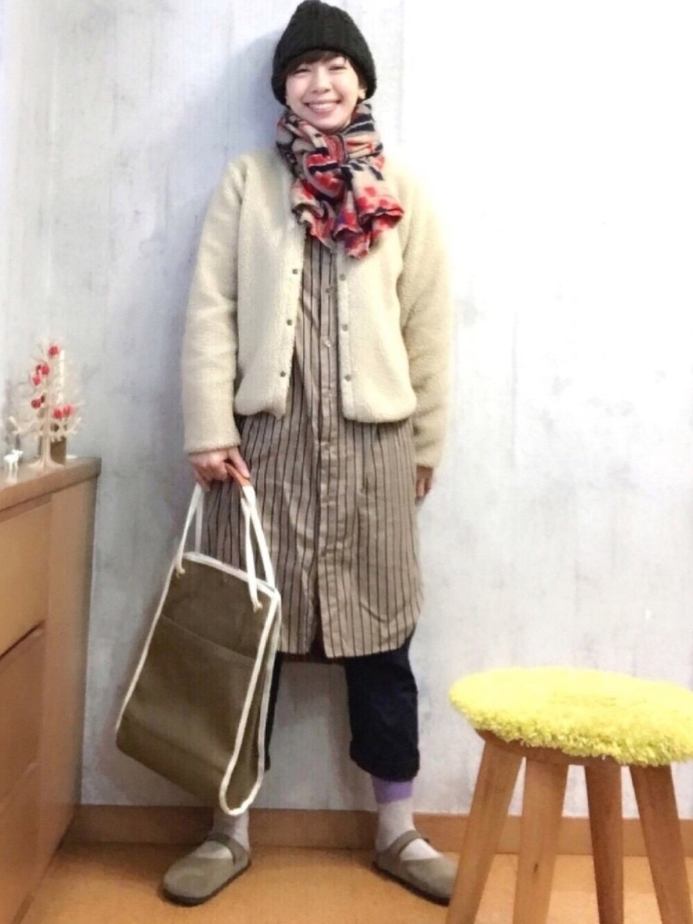 ベージュ系のノーカラージャケット、ブラウン系のシャツワンピース、グリーン系のトートバッグを着用したレディースの冬コーディネートの1枚目の写真