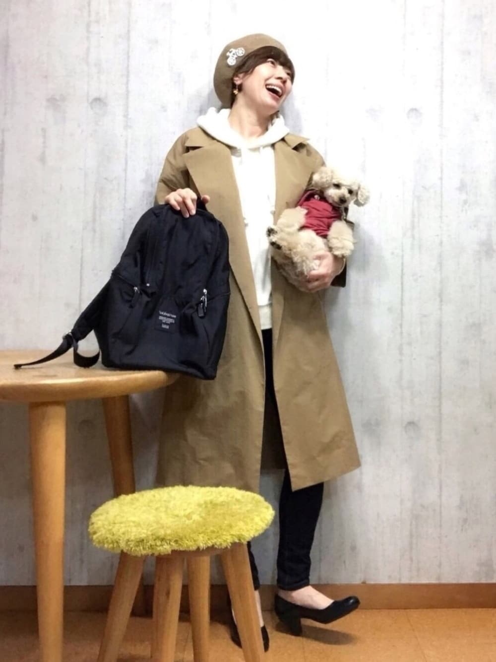 ブラック系のバックパック/リュック、ベージュ系のトレンチコート、ホワイト系のパーカーを着用したレディースの春コーディネートの1枚目の写真