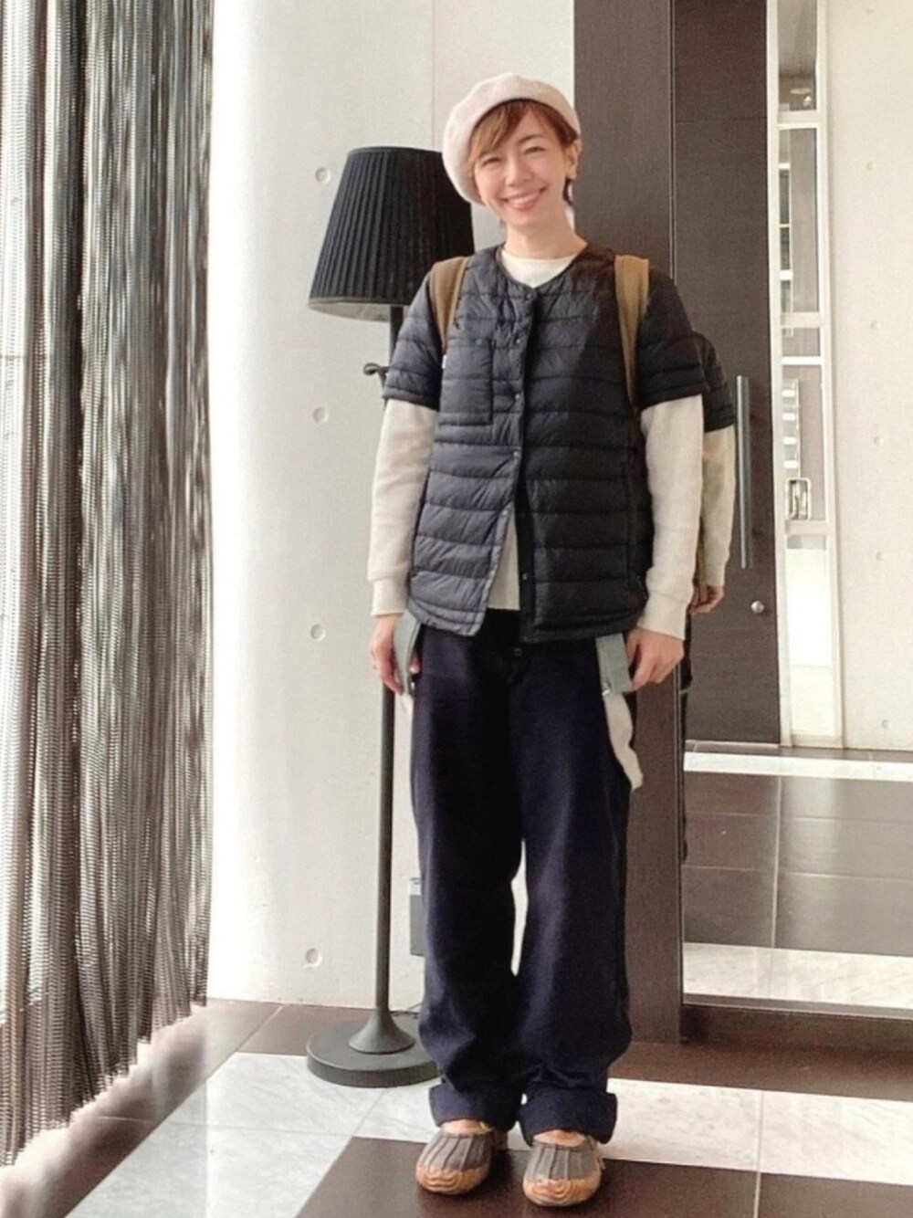 ブラック系のダウンベスト、ホワイト系のTシャツ/カットソー、ブルー系のその他パンツを着用したレディースの秋コーディネートの1枚目の写真