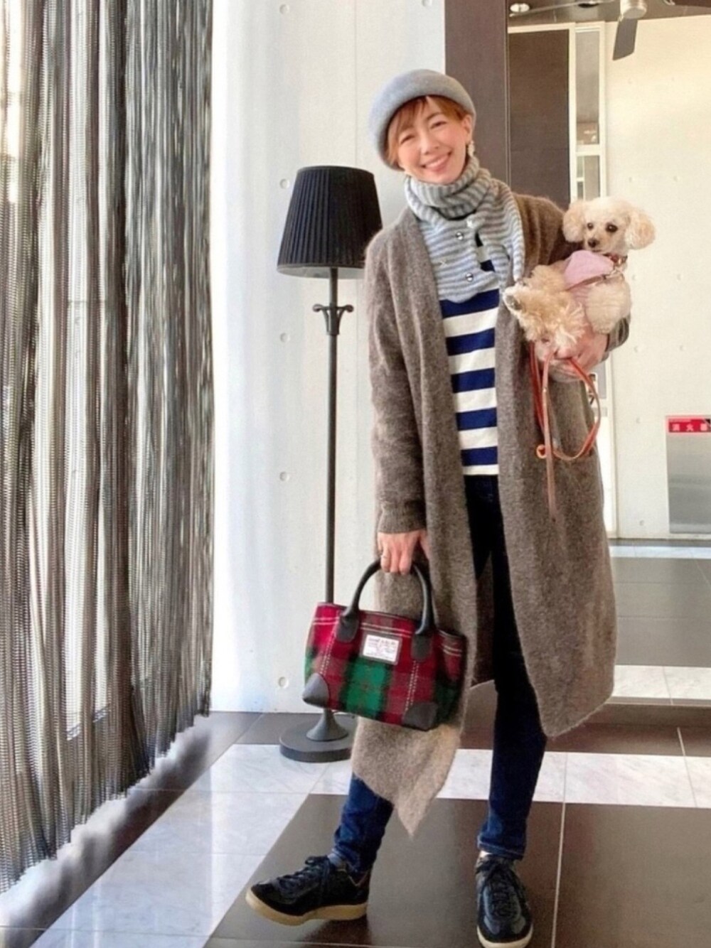 ブラウン系のカーディガン/ボレロ、ブルー系のTシャツ/カットソー、ブルー系のデニムパンツを着用したレディースの秋コーディネートの1枚目の写真