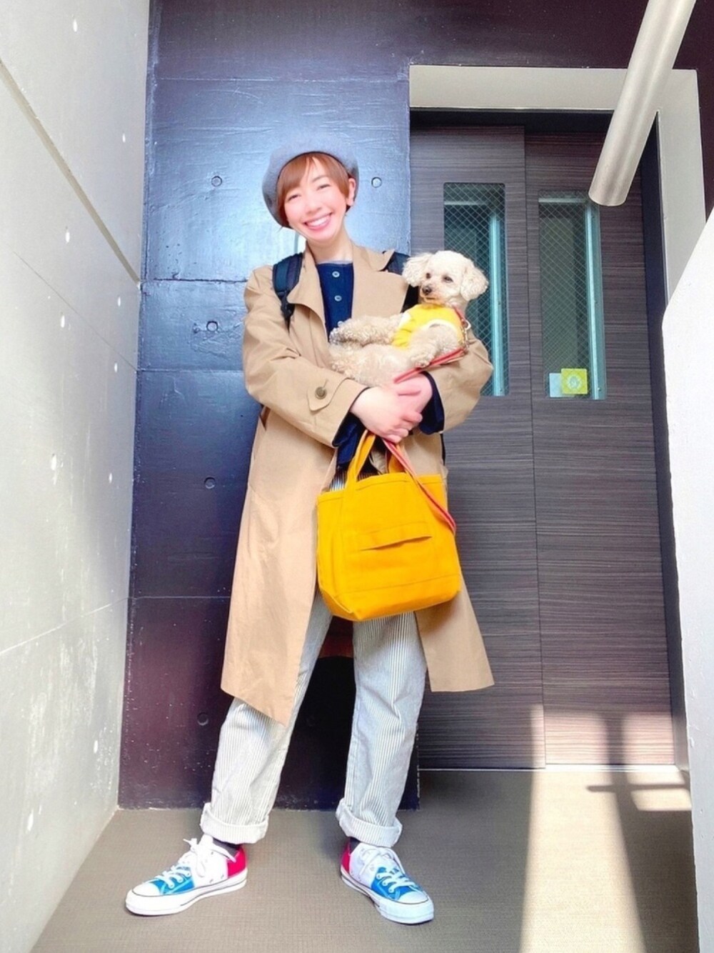 ブルー系のカーディガン/ボレロ、ベージュ系のトレンチコート、イエロー系のトートバッグを着用したレディースの春コーディネートの1枚目の写真