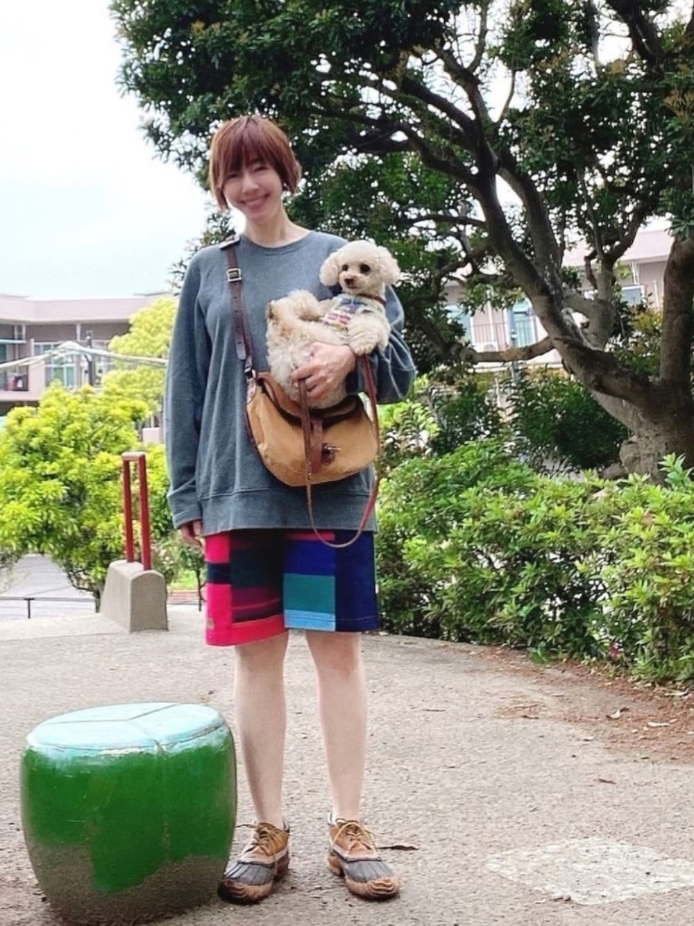 グレー系のスウェット、レッド系のその他パンツ、イエロー系のショルダーバッグを着用したレディースの春コーディネートの1枚目の写真