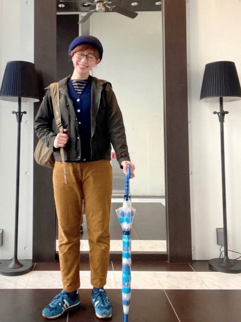 グレー系のTシャツ/カットソー、ブルー系のカーディガン/ボレロ、グリーン系のナイロンジャケットを着用したレディースの春コーディネートの1枚目の写真