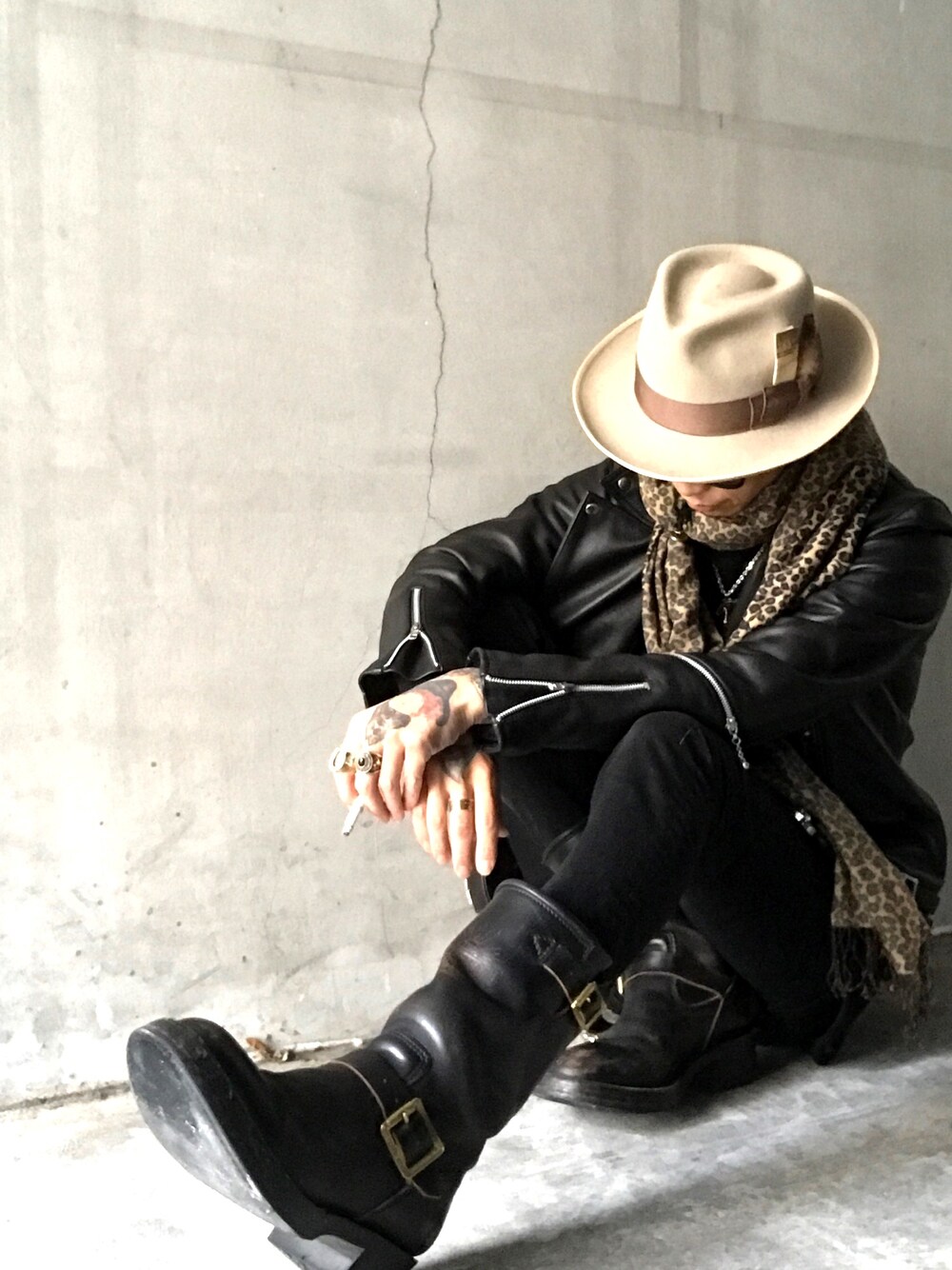 ブラック系のデニムパンツ、ブラック系のブーツ、ベージュ系のハットを着用したメンズの冬コーディネートの1枚目の写真